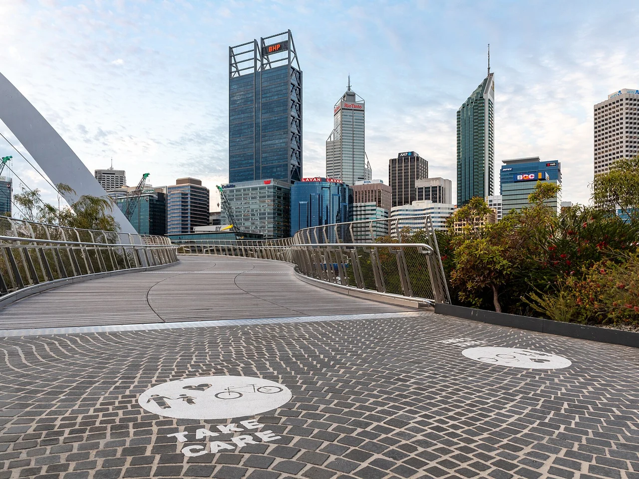 The Elizabeth Quay pedestrian bridge leading toward the Perth CBD skyline on the Swan River.